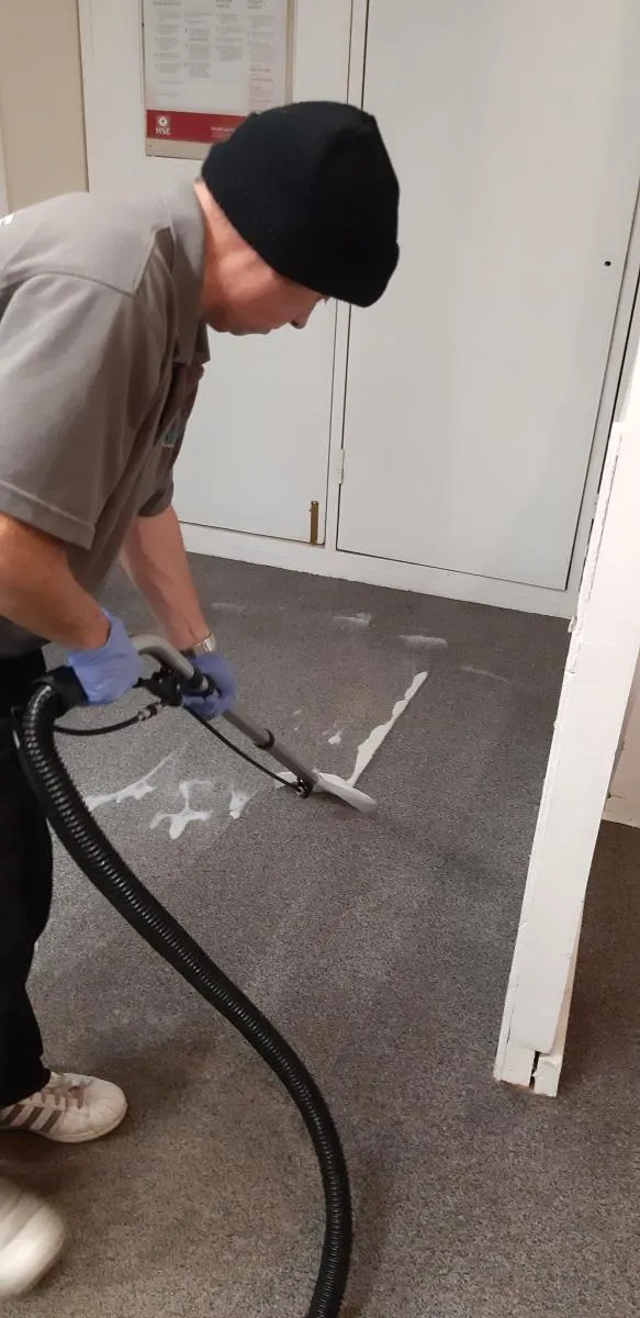Millers cleaner using carpet extraction equipment on a grey office carpet